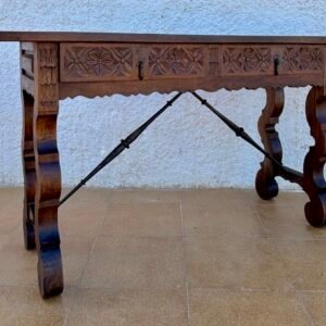 Mesa consola española con dos cajones tallados y camilla de hierro, década de 1890